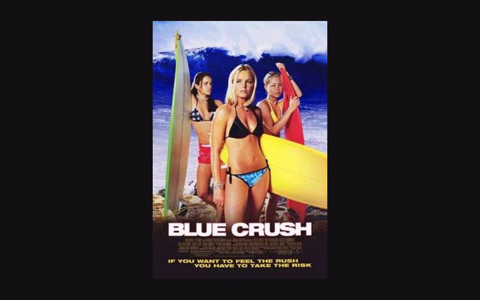 Movie poster for "Blue Crush" showing three women holding surfboards before a large wave