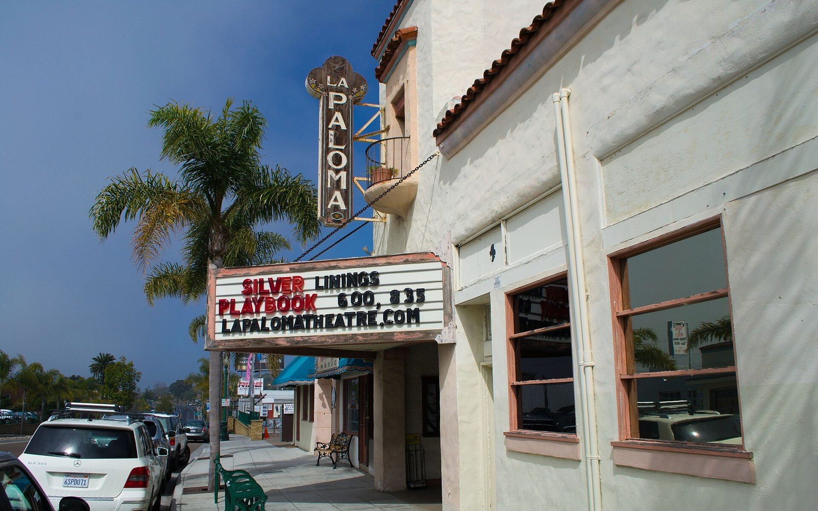 La Paloma Theatre's marquee sign advertises showtimes for Silver Linings Playbook on a palm-lined street